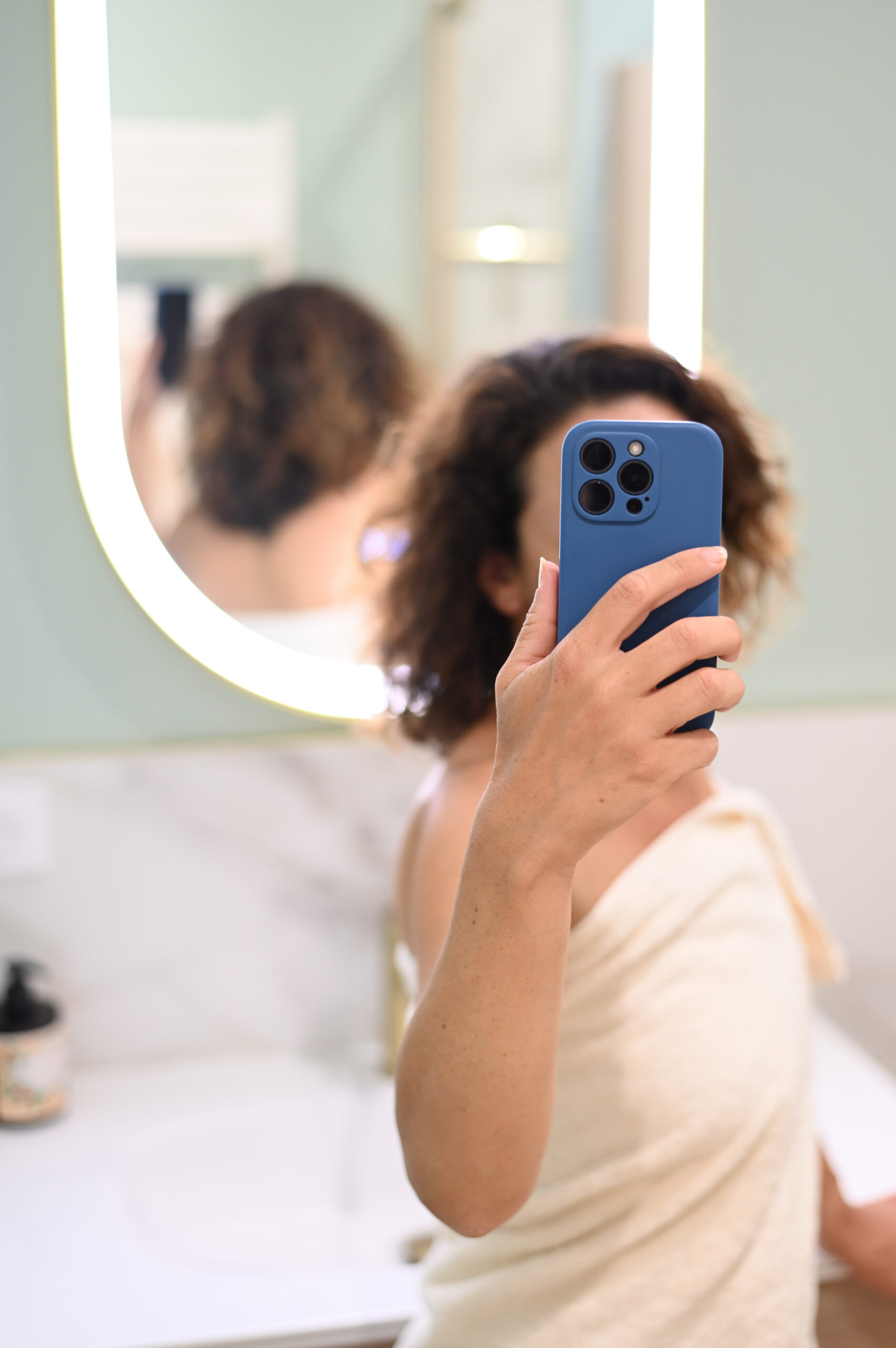 Nainen ottaa peili-selfien sinisellä matkapuhelimella
